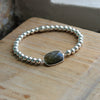 Labradorite bezel stone incased in silver with silver beads strung on elastic designed by Margie Edwards jewelry.  