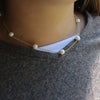 White 8mm pearls with delicate chain in-between. This is a Margie Edwards Jewelry design. Worn at  just below the neck with a white tee shirt and sweater. 