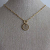 Shown on a jewelry display neck.  The gold necklace with an enhancer with circle pendant is at 16 inches in length. Margie Edwards Jewelry Designs 