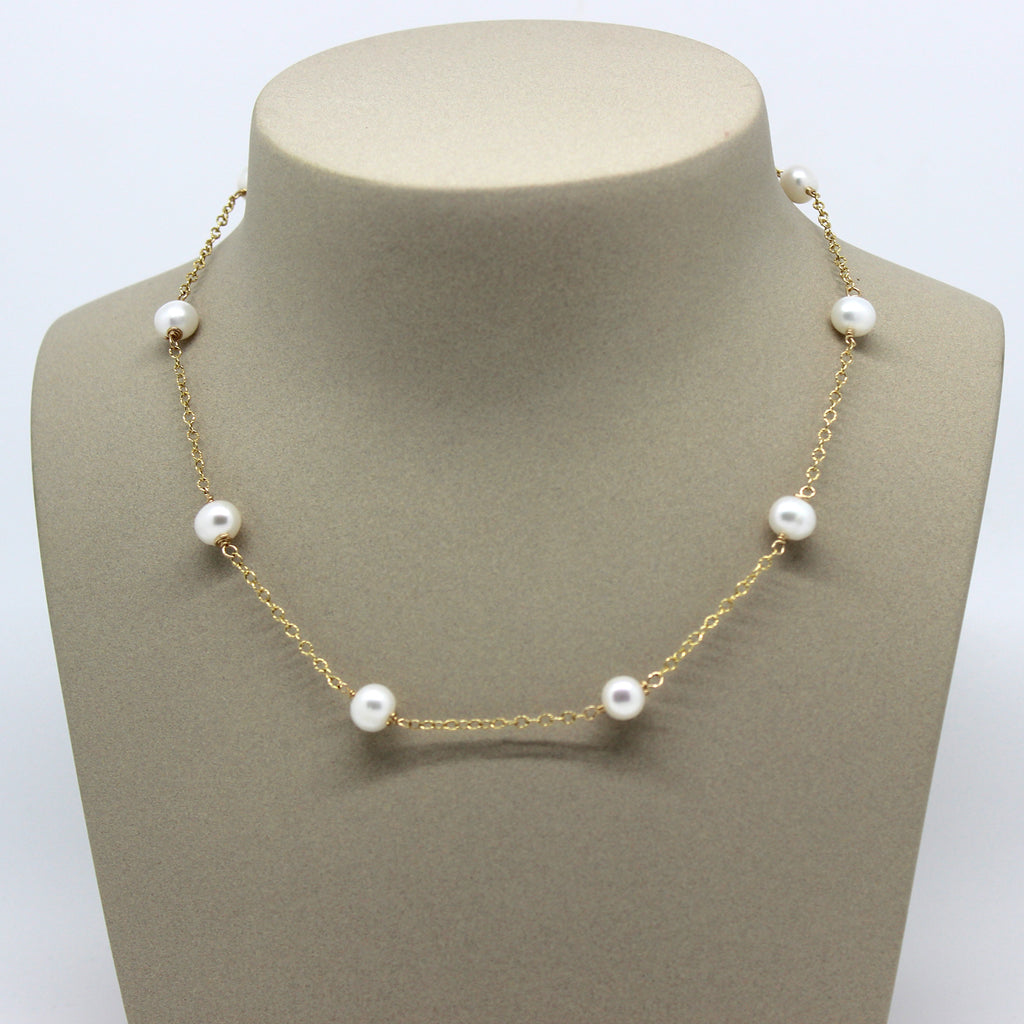 White 8mm pearls with delicate  14kt gold-filled chain in-between. This is a Margie Edwards Jewelry design.  Shown on a jewelry neck.