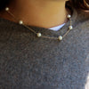 White 8mm pearls with delicate silver chain in-between. This is a Margie Edwards Jewelry design. Worn at just below the neck with a white tee shirt and sweater.